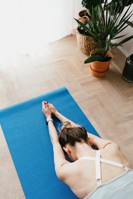 A serene woman practicing yoga at home in a cozy, sunlit room.